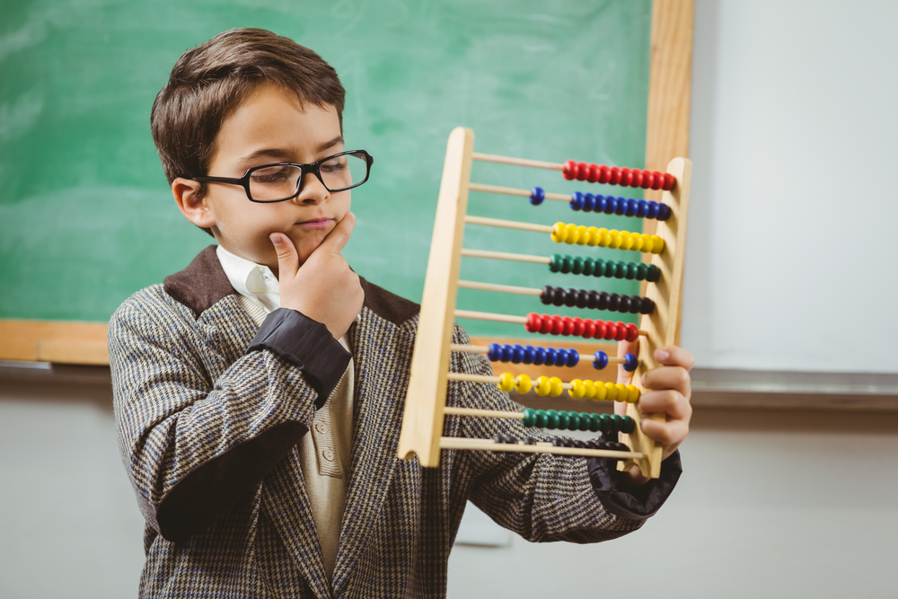 Pupil,Dressed,Up,As,Teacher,Holding,Abacus,In,A,Classroom